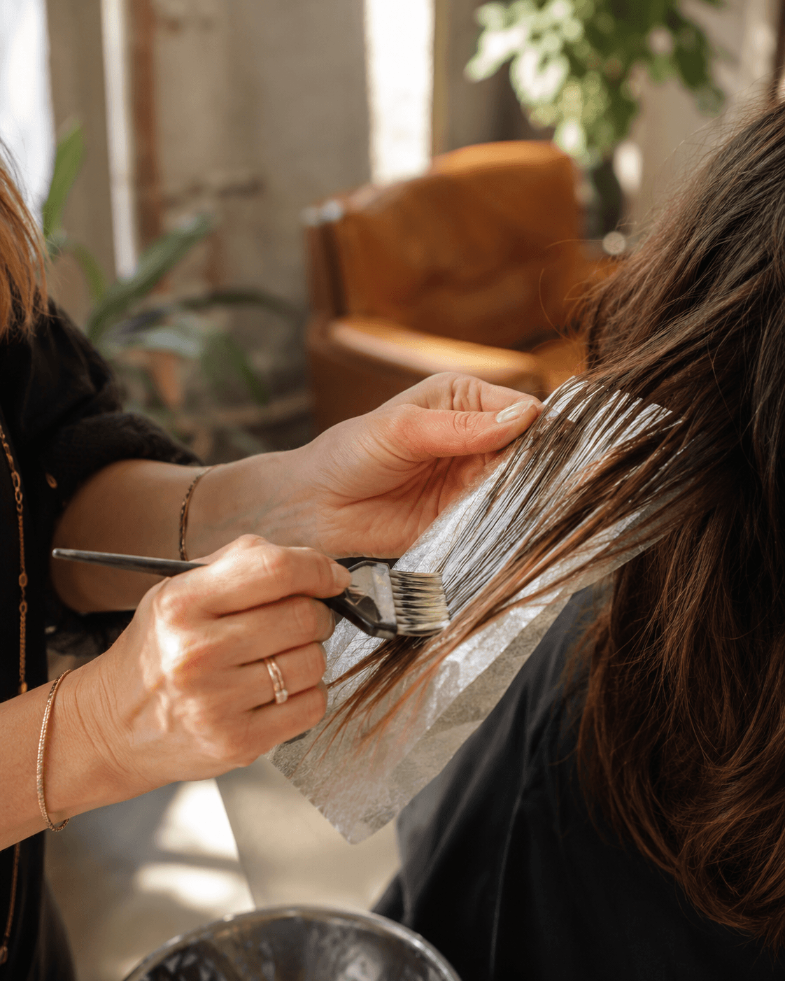 Coiffeuse réalisant un brushing dans un salon lumineux